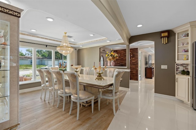 dining room with arched walkways, baseboards, light wood-style flooring, and recessed lighting