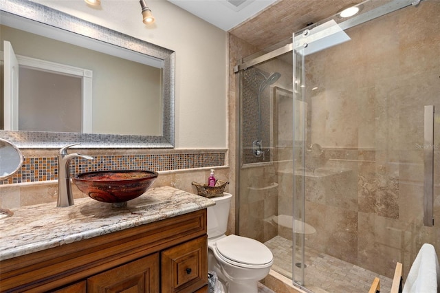 full bath featuring toilet, a stall shower, decorative backsplash, and vanity