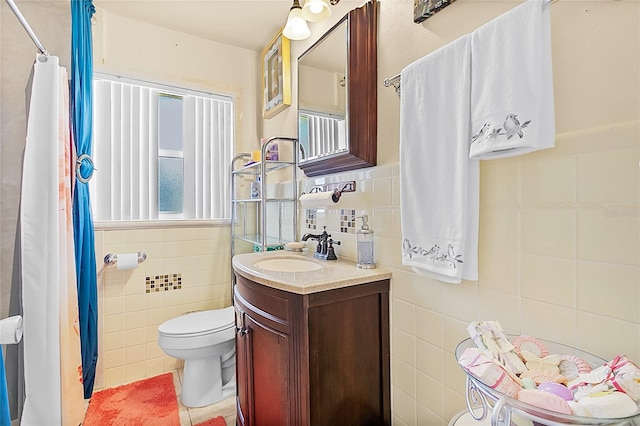 bathroom with a shower with curtain, vanity, toilet, and tile walls