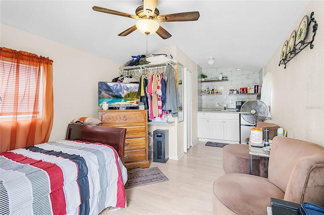 bedroom featuring light hardwood / wood-style floors, lofted ceiling, and ceiling fan