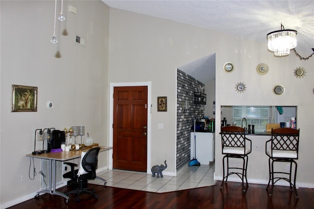 interior space featuring light hardwood / wood-style floors, a textured ceiling, and an inviting chandelier