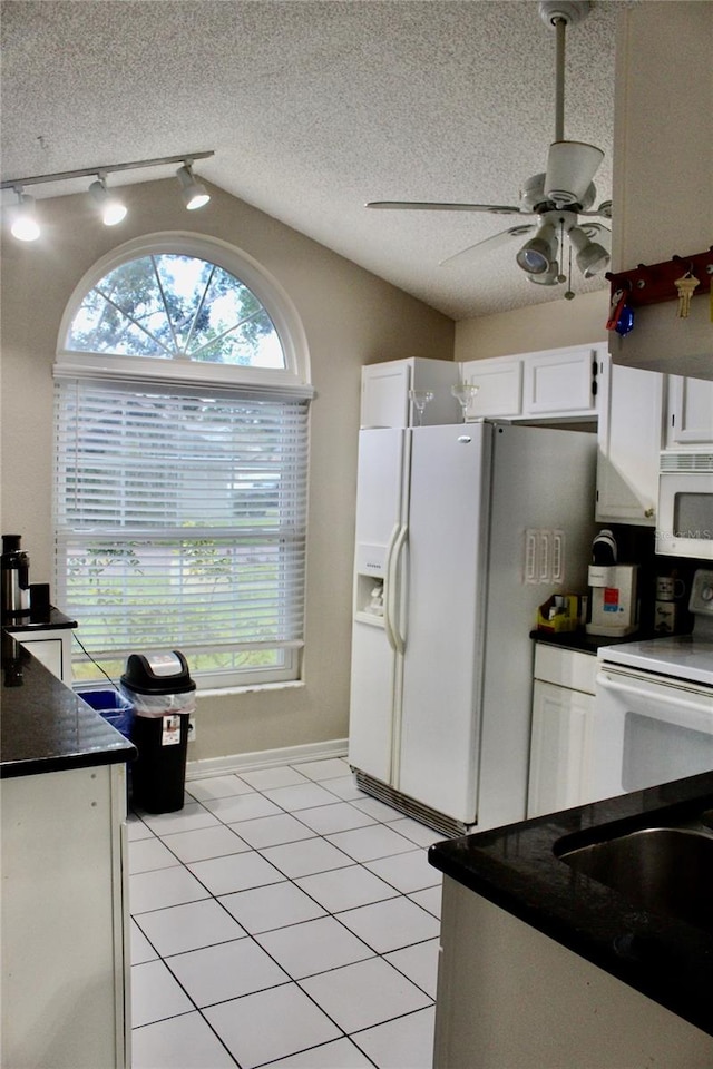 kitchen featuring white cabinets, a textured ceiling, light tile patterned floors, ceiling fan, and white appliances