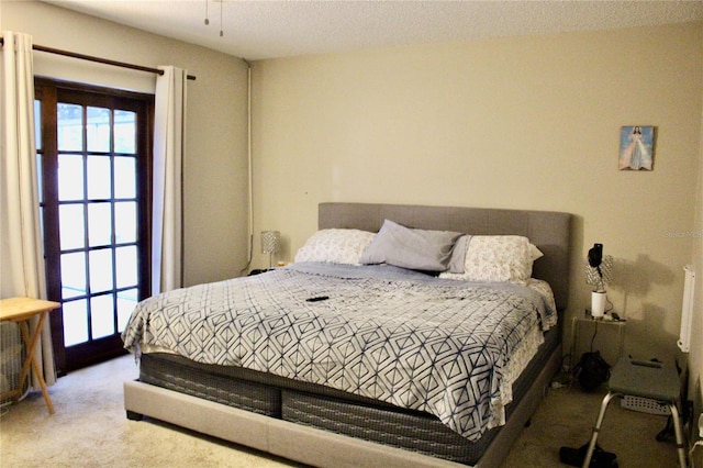 carpeted bedroom featuring access to exterior and a textured ceiling