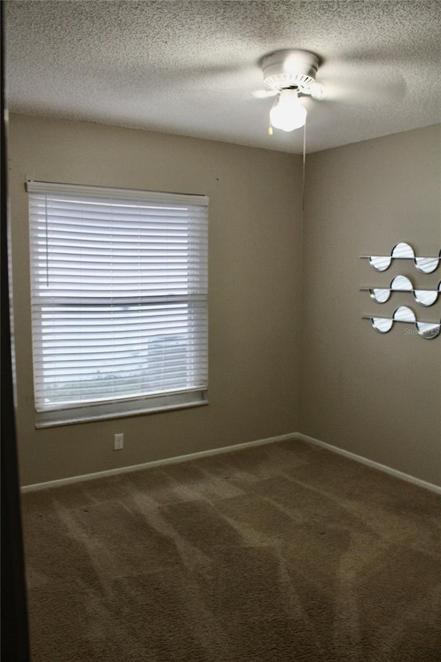 spare room featuring ceiling fan, a textured ceiling, and carpet flooring