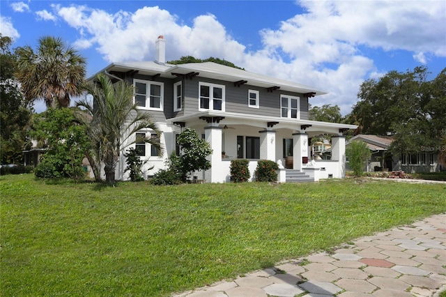 view of front facade featuring ceiling fan, a front yard, and a porch