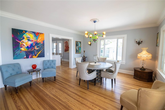 dining area with a chandelier, light hardwood / wood-style floors, and crown molding