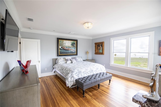 bedroom with hardwood / wood-style flooring and ornamental molding