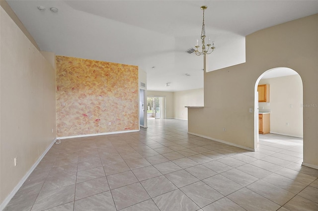 empty room with light tile patterned floors and a notable chandelier