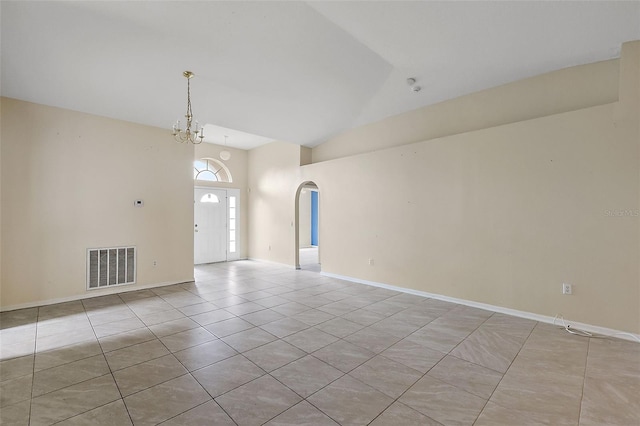 tiled spare room with lofted ceiling and an inviting chandelier