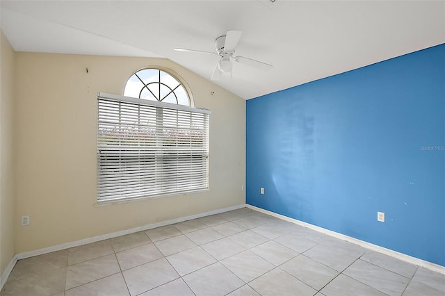 unfurnished room featuring ceiling fan, light tile patterned floors, and vaulted ceiling