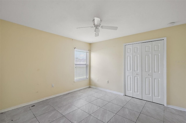 unfurnished bedroom featuring light tile patterned flooring, ceiling fan, and a closet