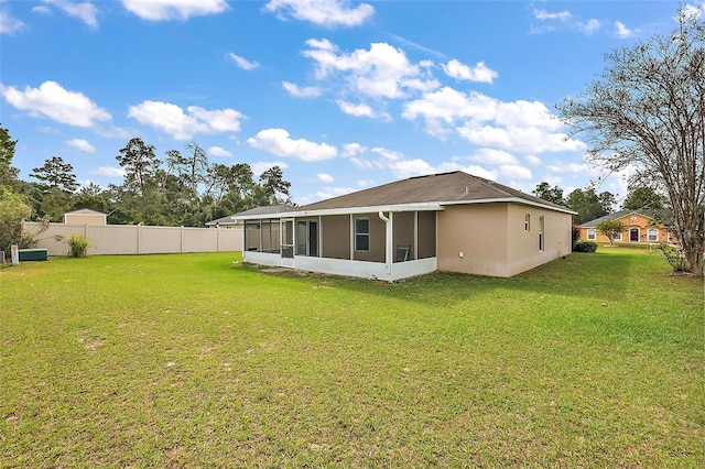 rear view of house with a lawn and a sunroom