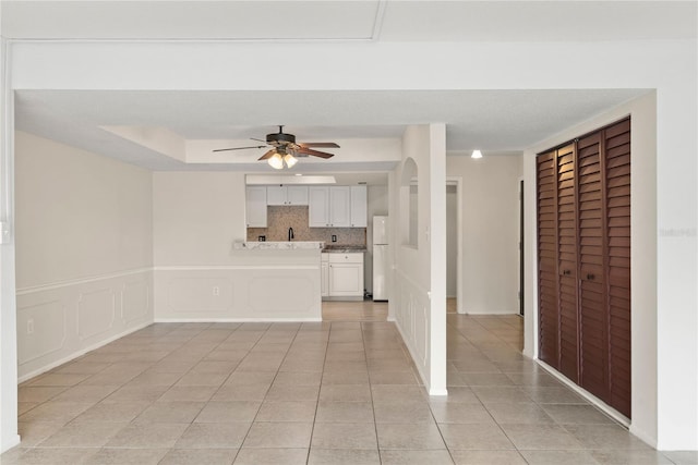 unfurnished living room with ceiling fan and light tile patterned flooring