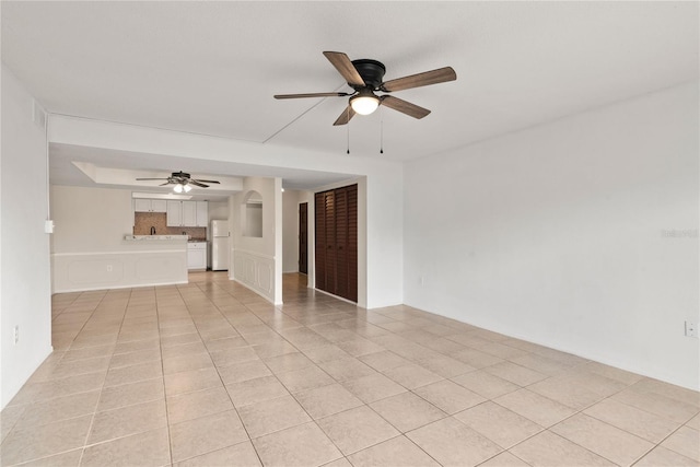 unfurnished living room with light tile patterned floors and ceiling fan