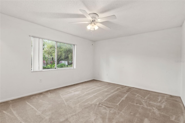 empty room with a textured ceiling, carpet flooring, and ceiling fan