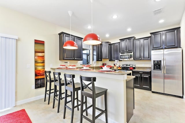 1423 Thunderbird Rd, Davenport, FL 33896 - kitchen with stainless steel appliances, a kitchen bar, hanging light fixtures, a peninsula, and recessed lighting