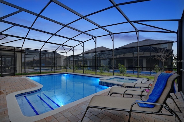 view of swimming pool with glass enclosure, a patio, and an in ground hot tub