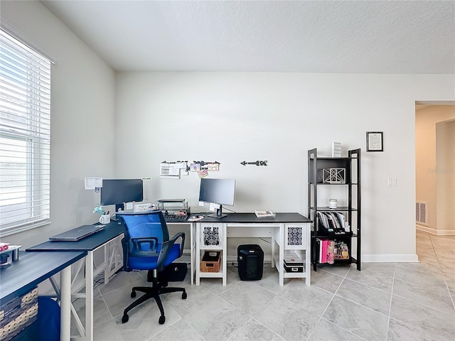 tiled home office with a textured ceiling