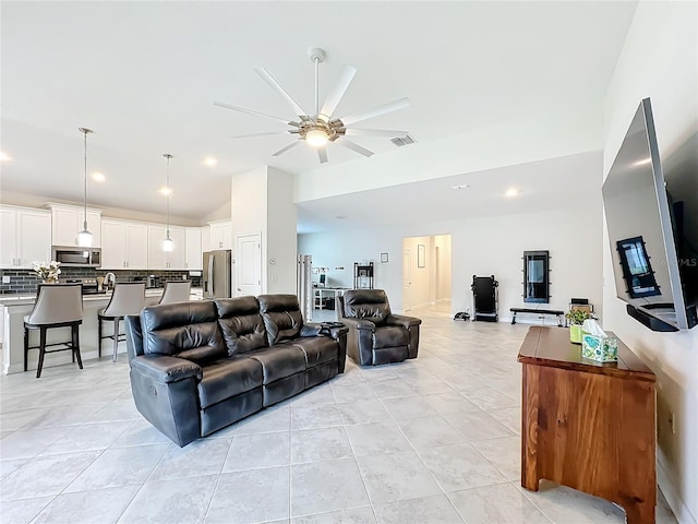 living room featuring vaulted ceiling, light tile patterned floors, and ceiling fan