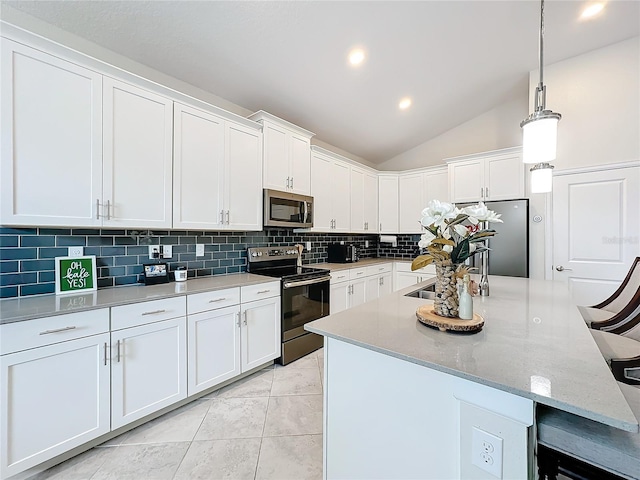 kitchen featuring vaulted ceiling, white cabinets, light tile patterned flooring, pendant lighting, and appliances with stainless steel finishes