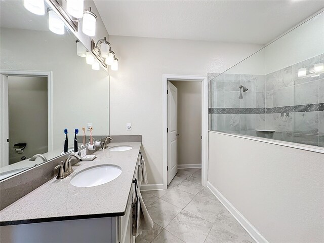 1490 Olympic Club Blvd, Champions Gate, FL 33896 - bathroom with marble finish flooring, double vanity, walk in shower, and baseboards