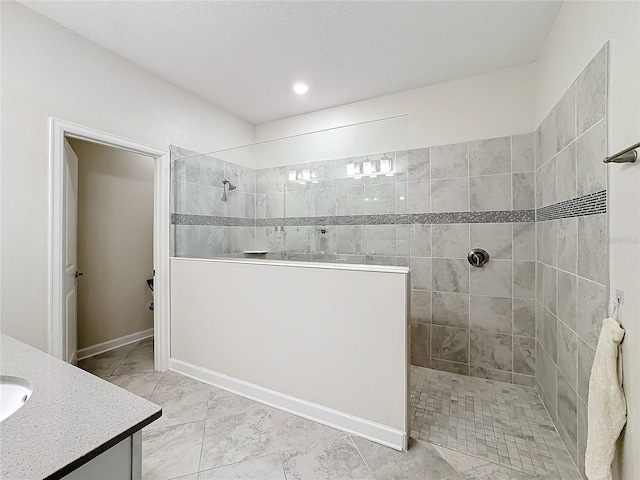 bathroom with vanity and tiled shower