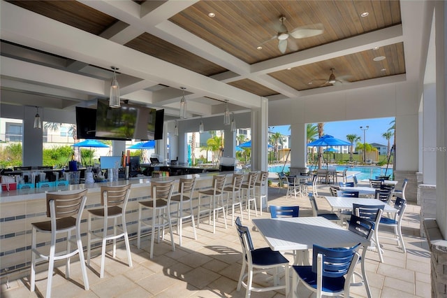 view of patio with a community pool and ceiling fan