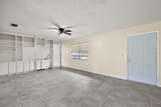 empty room featuring light tile patterned flooring, ceiling fan, and a textured ceiling