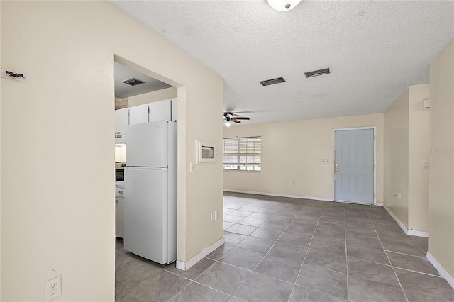 interior space featuring a textured ceiling and light tile patterned floors