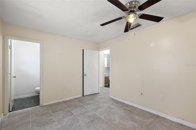 unfurnished bedroom with a textured ceiling, ensuite bath, ceiling fan, and light tile patterned flooring