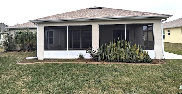 rear view of property featuring a sunroom and a lawn