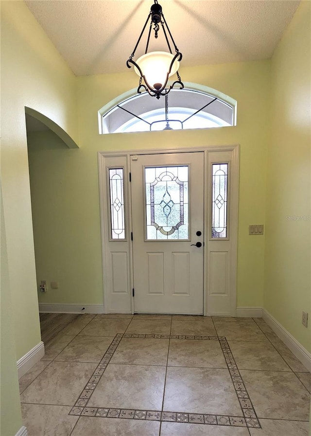 entrance foyer with light tile patterned flooring and a textured ceiling