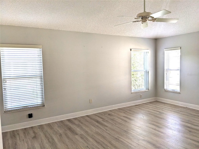 empty room featuring ceiling fan, dark hardwood / wood-style flooring, and a textured ceiling