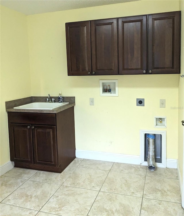 washroom featuring cabinets, sink, hookup for a washing machine, hookup for an electric dryer, and light tile patterned floors