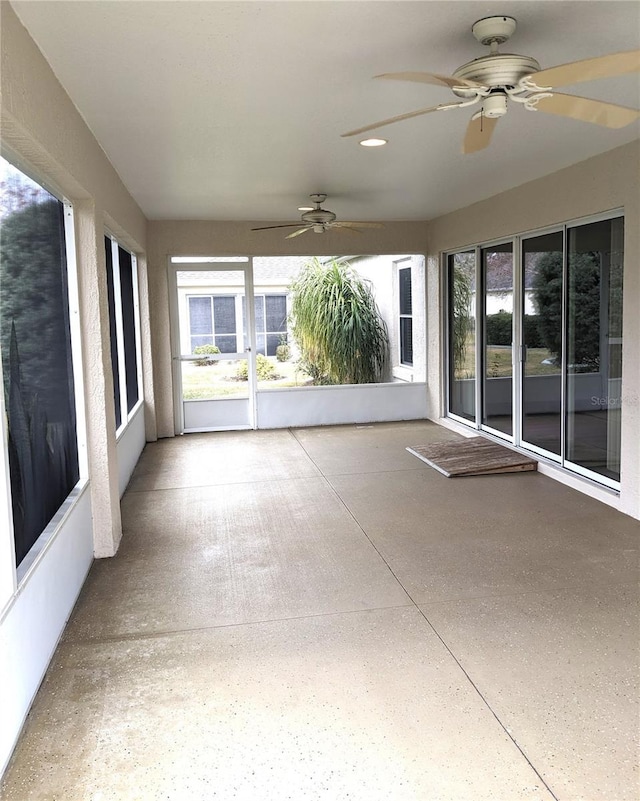 unfurnished sunroom with ceiling fan