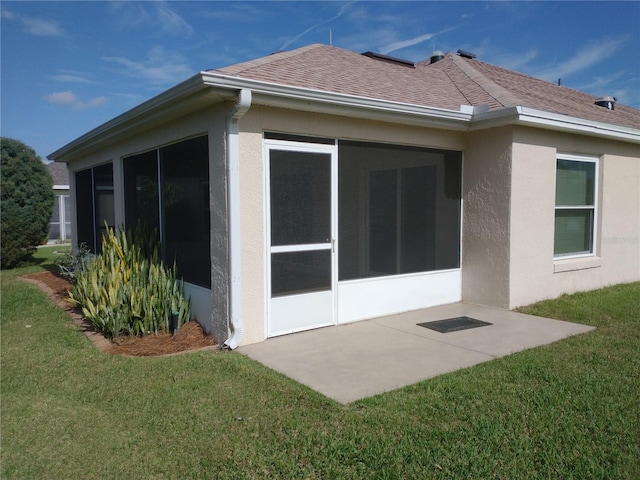 view of side of home featuring a sunroom and a lawn