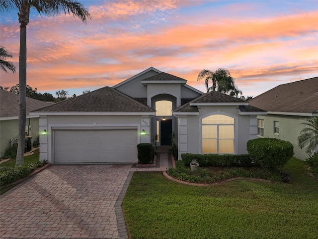 view of front of property with a garage and a lawn