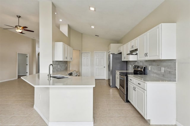 235 Royal Palm Dr, Davenport, FL 33837 - kitchen featuring stainless steel appliances, a sink, under cabinet range hood, light tile patterned flooring, and high vaulted ceiling