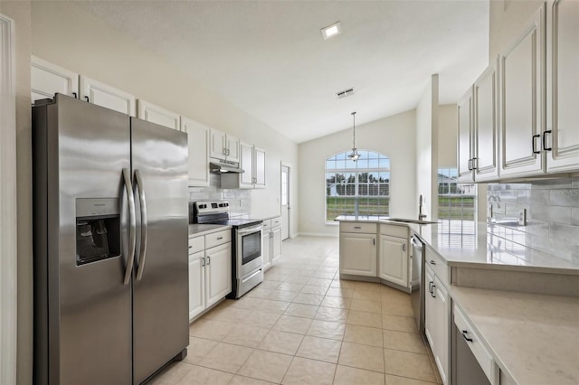 kitchen featuring stainless steel appliances, white cabinetry, backsplash, pendant lighting, and lofted ceiling