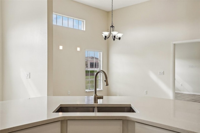 235 Royal Palm Dr, Davenport, FL 33837 - kitchen featuring a sink, white cabinetry, light countertops, decorative light fixtures, and a chandelier