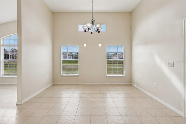 unfurnished dining area featuring a high ceiling, light tile patterned floors, and an inviting chandelier