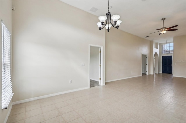235 Royal Palm Dr, Davenport, FL 33837 - unfurnished living room with a chandelier, a ceiling fan, arched walkways, a high ceiling, and baseboards