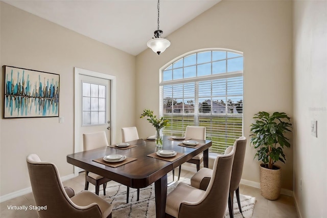 dining space featuring lofted ceiling and light tile patterned floors