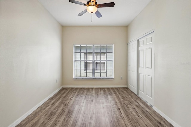 235 Royal Palm Dr, Davenport, FL 33837 - unfurnished bedroom featuring wood finished floors, baseboards, a closet, and ceiling fan