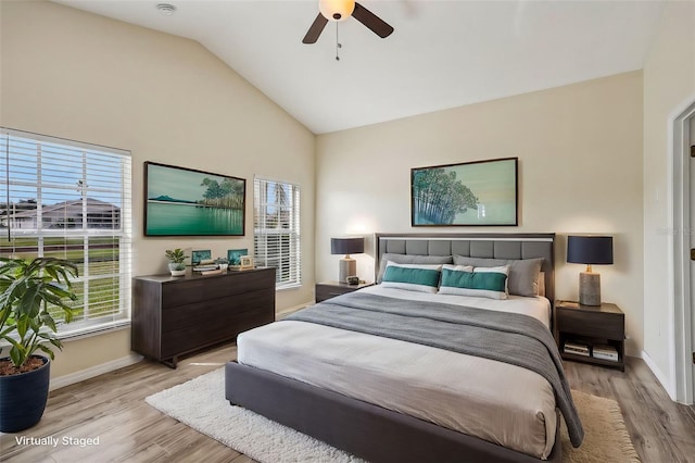 bedroom featuring light hardwood / wood-style floors, multiple windows, and vaulted ceiling