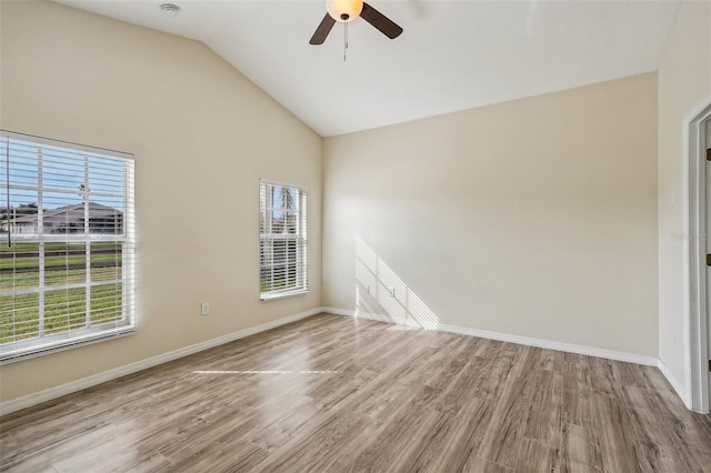 spare room with a wealth of natural light, light hardwood / wood-style floors, and vaulted ceiling