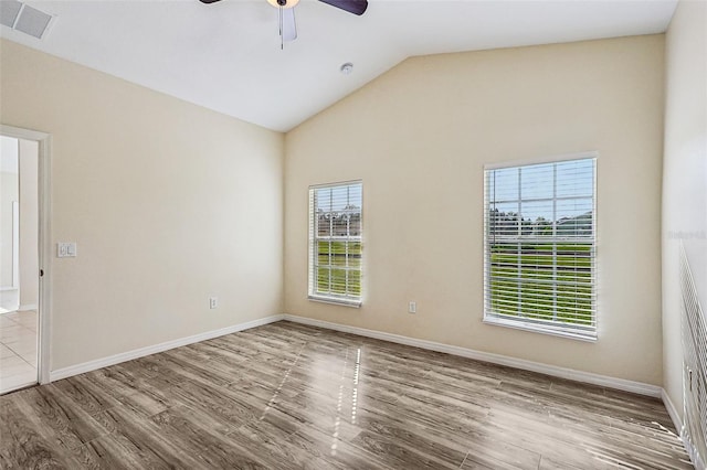 empty room featuring ceiling fan, light wood-type flooring, and lofted ceiling