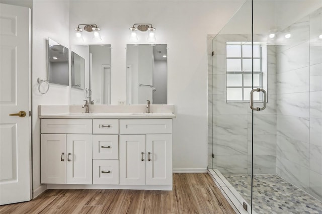 bathroom with wood-type flooring, vanity, and a shower with door