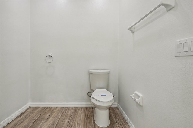 bathroom featuring hardwood / wood-style flooring and toilet