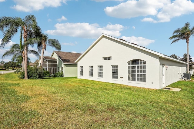 235 Royal Palm Dr, Davenport, FL 33837 - back of house with central air condition unit, a lawn, and stucco siding